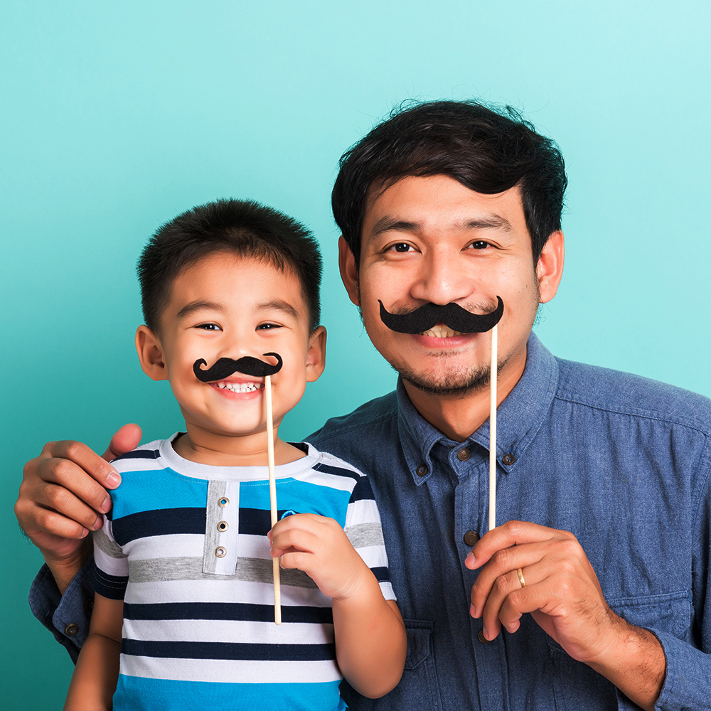 Dad and child smiling with funny mustaches