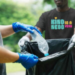 T-Shirt with "Kindness is a Verb" in bold bright fonts and colors. Showing personal style